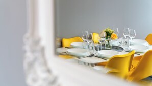 A dining table set with plates, glasses, and cutlery, surrounded by yellow chairs. - Fairfax Close, Amesbury, Wiltshire, SP47ST, United Kingdom (Amesbury)
