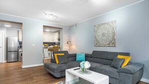 A modern living room with a grey sectional sofa, a white coffee table, and a patterned rug. - Fairfax Close, Amesbury, Wiltshire, SP47ST, United Kingdom (Amesbury)