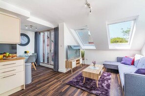A modern apartment with a loft bedroom, a dining area, and a living room with a sofa and a TV. - Chantry Street, Andover, Hampshire, SP101PB, United Kingdom (Andover)