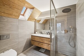 A modern bathroom with a wooden vanity, a glass shower enclosure, and a skylight. - Starlight by Mrs Miggins (Crans-Montana)