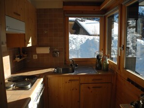 Eine Holz-Küche mit Blick auf einen verschneiten Berg.