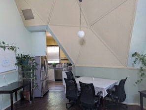 Comedor con mesa, sillas y una pizarra con notas.
