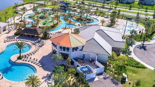 Un complexe hôtelier doté d’une grande piscine, d’un parc aquatique et d’un bâtiment au toit rouge.