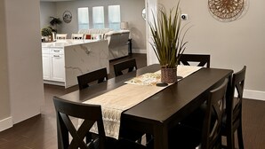 Un comedor con mesa, sillas y ventilador de techo.