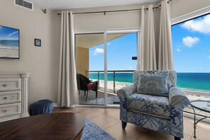 Une pièce avec vue sur la plage, un canapé, une table à manger et une chaise.