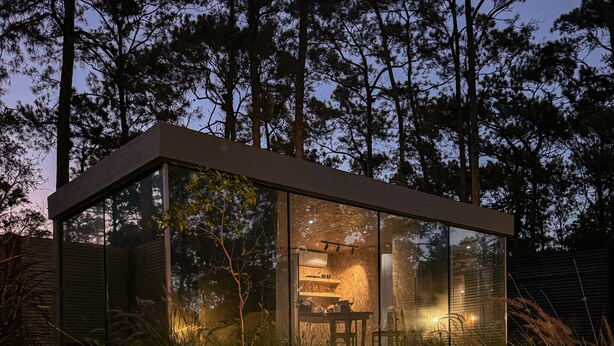 A modern glass structure with a fire pit in the foreground. - Cozy Cabin, Jacuzzi, AC, Fireplace and Hot water. (Jarabacoa)