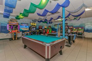 A pool table in a room with arcade games and a mural. - Ocean Lakes 1586 (Myrtle Beach)