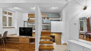 Un interno moderno con una scala in legno, un'area pranzo e una cucina.