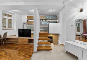 Un interior moderno con una escalera de madera, un comedor y una cocina.