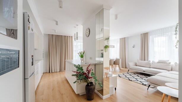 Ein modernes Wohnzimmer mit Sofa, Couchtisch und Essbereich.