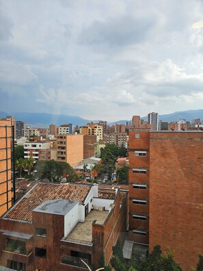 A cityscape with a mix of modern and traditional buildings, including a prominent brick structure with a flat roof. - InnerBloom Your loft in the best neighborhood in Medellín, just 5 minutes from the stadium. (Medellín)