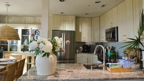 A kitchen with white cabinets, a stainless steel refrigerator, a microwave, and a sink. - Oceanfront Sanctuary in Hilton Head Island (Hilton Head Island)
