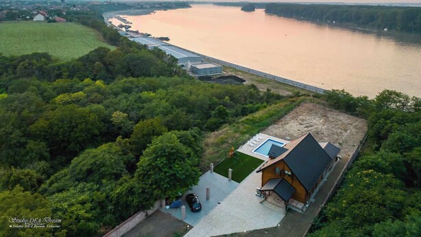 An aerial view of a riverside property with a house, a swimming pool, and a dock. - House by the Danube with jacuzzi, pool and kids’ playground (Vukovar)