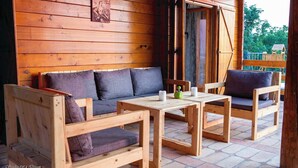 A wooden cabin with a sofa, two chairs, and a table. - House by the Danube with jacuzzi, pool and kids’ playground (Vukovar)
