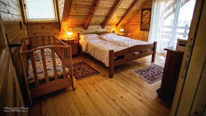 A cozy attic bedroom with a wooden crib, a single bed, and a nightstand with a lamp. - House by the Danube with jacuzzi, pool and kids’ playground (Vukovar)