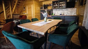 A cozy wooden interior with a dining area, a kitchen, and a staircase. - House by the Danube with jacuzzi, pool and kids’ playground (Vukovar)