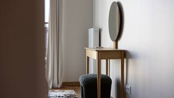 A minimalist room with a wooden table, a mirror, and a small white appliance.