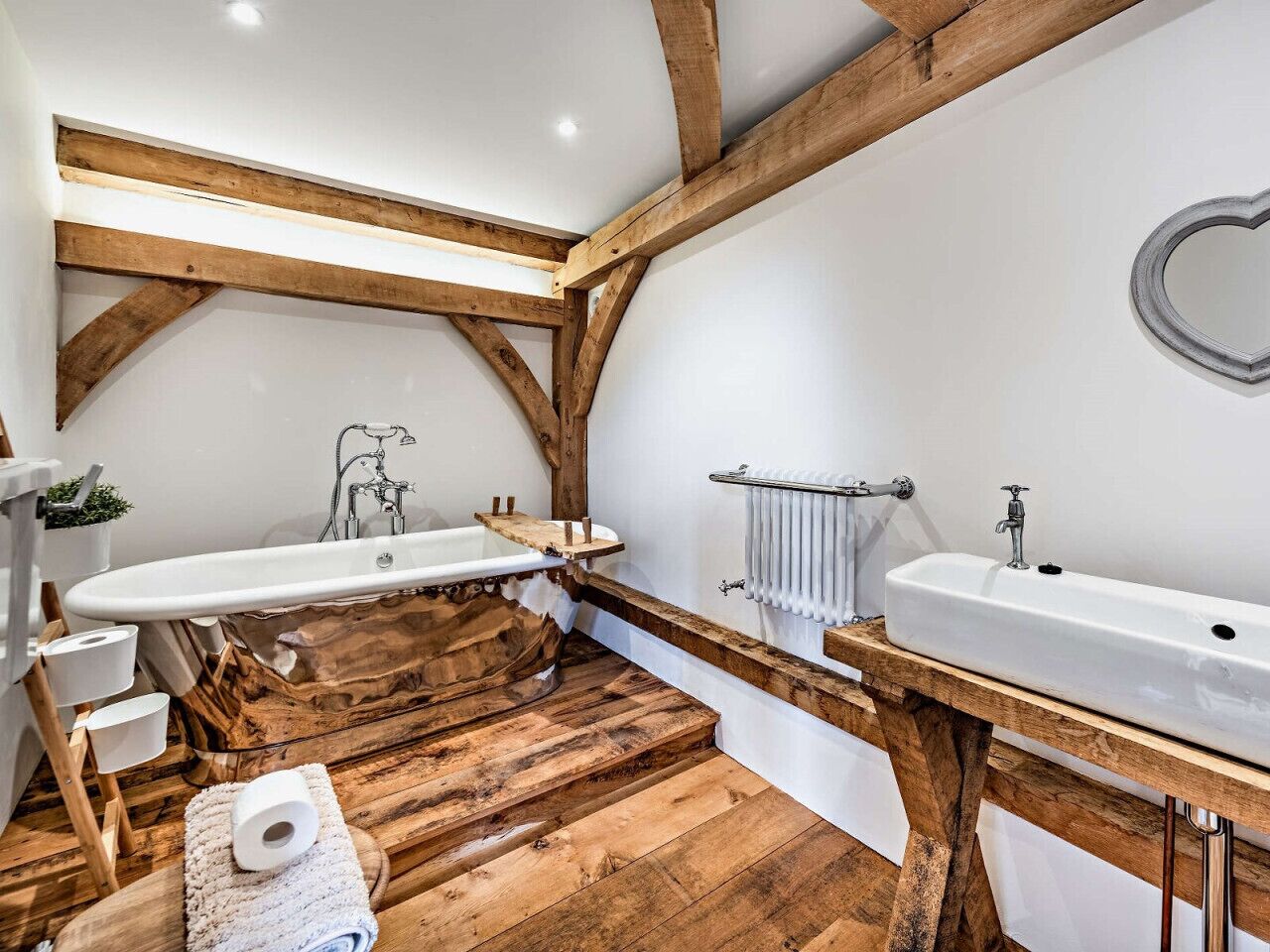 A bathroom with wooden beams, a wooden bathtub, and a wooden vanity with a sink.