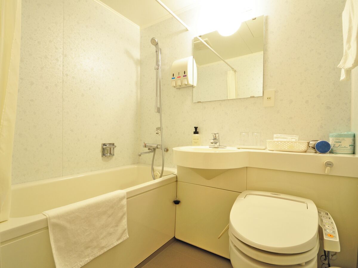 Un bagno con vasca, WC, lavabo e specchio.