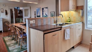 A modern kitchen with a central island, a sink, and wooden cabinets. - Awesome home in Fiskebäckskil with house sea view (Fiskebäckskil)