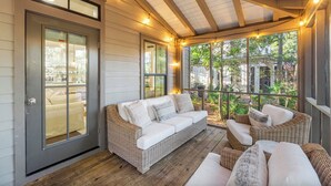 A covered porch with wicker furniture, a sliding glass door, and a view of the outdoors. - Sleeps 14 | Bikes | Sunshine State of Mind | 30A | Pool | Beach Access (Inlet Beach)