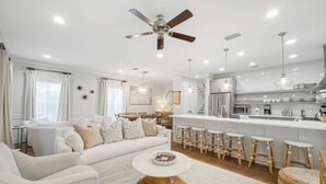 A modern living room with a white sofa, a round coffee table, and a ceiling fan. - Sleeps 14 | Bikes | Sunshine State of Mind | 30A | Pool | Beach Access (Inlet Beach)
