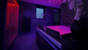 Une salle de bain moderne avec une douche à parois de verre, un meuble-lavabo avec un miroir et un lavabo fixé au mur.