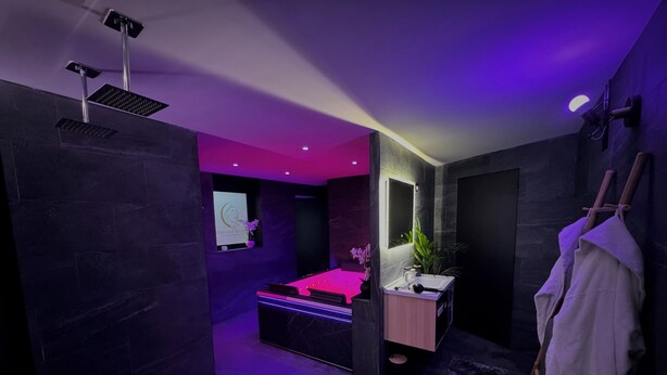 Une salle de bain moderne avec un grand miroir, un lavabo et un porte-serviettes.