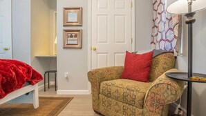 A room with a patterned sofa, a red throw blanket, a white door, and a lamp. - FIREFLY LODGE E (Gatlinburg)
