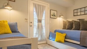 A room with a bed, a bench, and a door with curtains. - FIREFLY LODGE E (Gatlinburg)