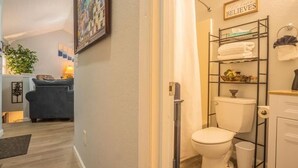 A modern bathroom with a toilet, a shelf with towels, and a sign that says "Believe." - FIREFLY LODGE E (Gatlinburg)