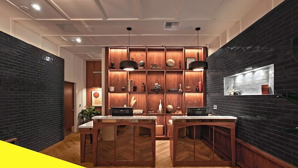 A modern kitchen with wooden cabinetry, a herringbone floor, and pendant lighting.