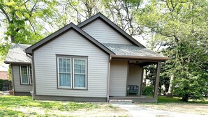 A residential house with a paved driveway leading to a covered porch.