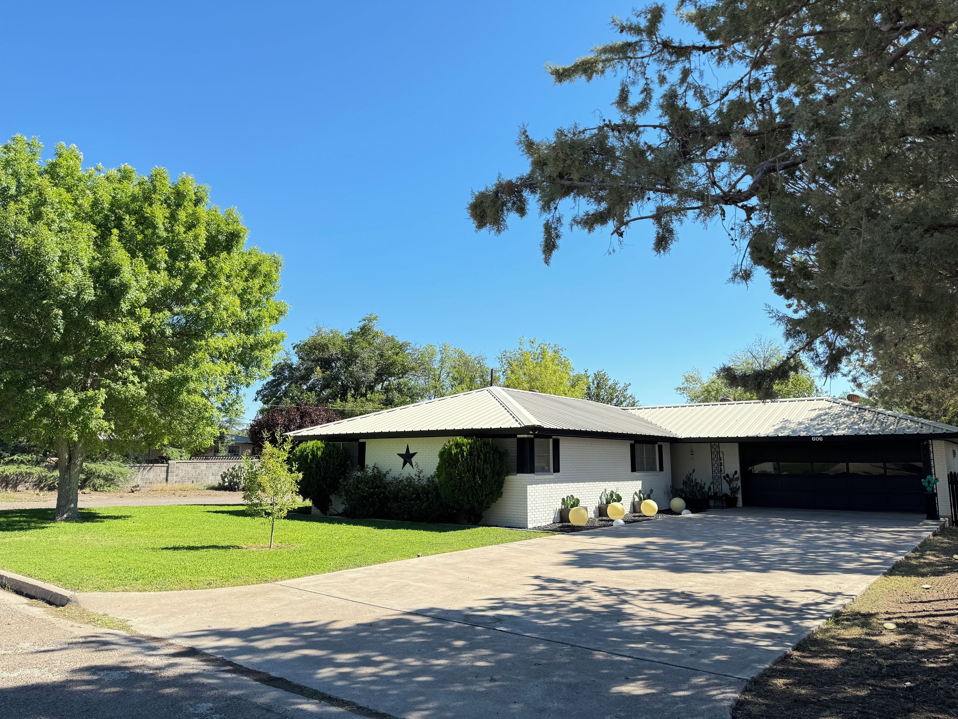 Ein Wohnhaus mit Garage, Rasen und Baum.