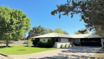 Ein Wohnhaus mit Garage, Rasen und Baum.