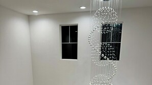 Una escalera con barandas blancas y una lámpara moderna.
