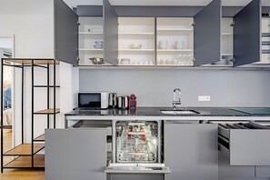 A modern kitchen with grey cabinetry, a built-in dishwasher, a microwave, and a sink. - Blueground | Wollishofen, terrace, nr Lake Zürich (Zurich)