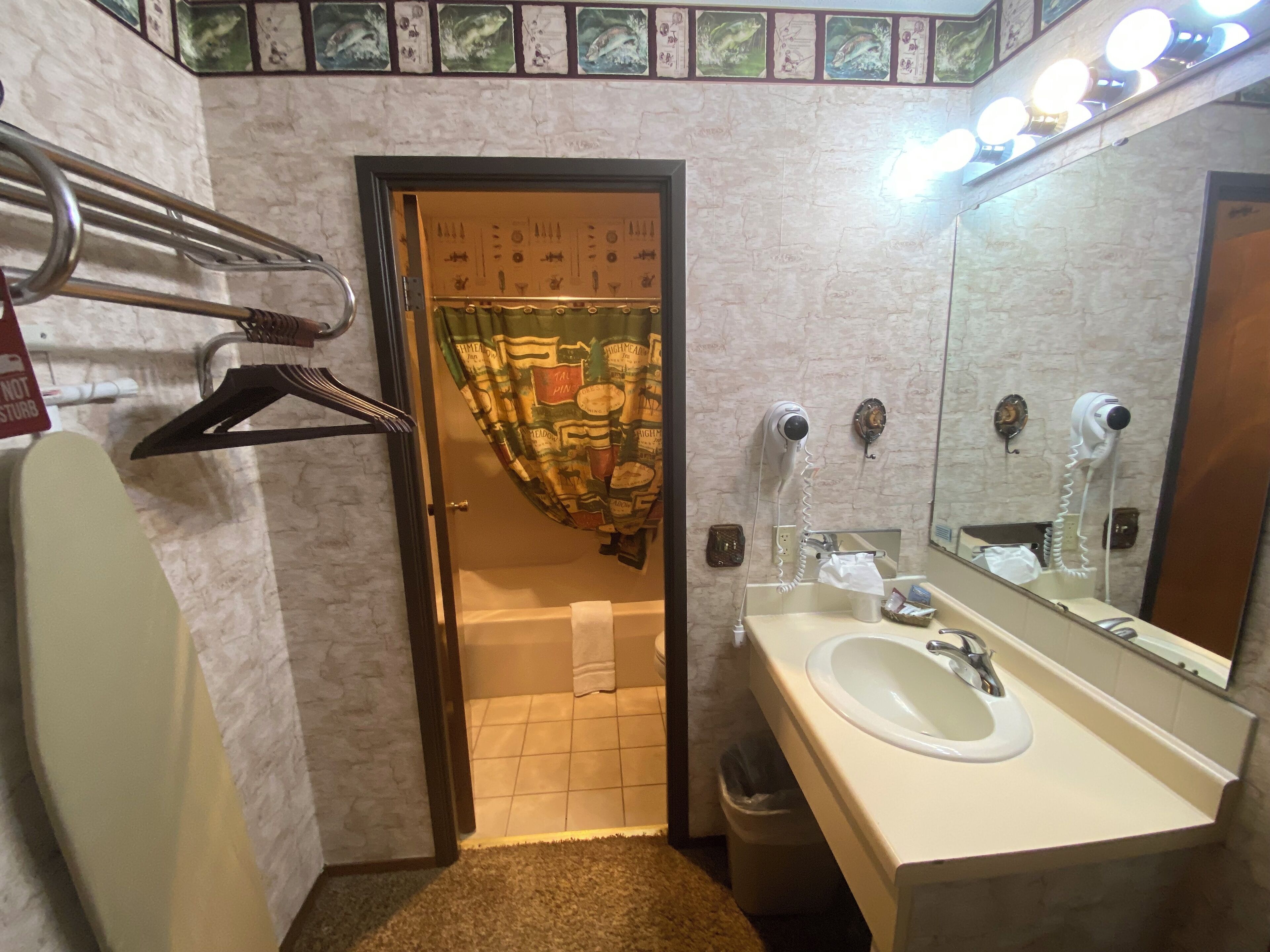 Un baño con lavamanos, espejo y barra para toallas.