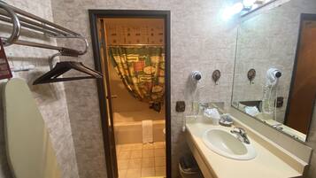 Un baño con lavamanos, espejo y barra para toallas.