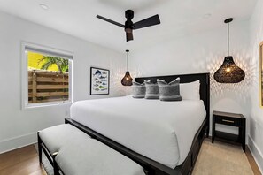 A modern bedroom with a large bed, a ceiling fan, and two pendant lights. - Heated Pool | Spa | Free Golf Cart | Steps 2 Beach (Anna Maria)