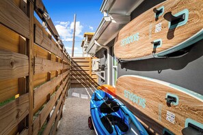Un estrecho callejón con cercas de madera a un lado y un edificio con techo inclinado al otro.
