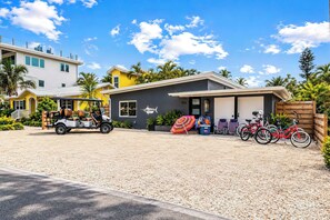 Ein modernes Gebäude mit Garage, Golfwagen und Fahrrädern.