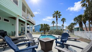 A poolside area with Adirondack chairs, a barbecue grill, and a small fire pit. - Private Pool, Shared Pool, Boardwalk to the Beach (Port Aransas)