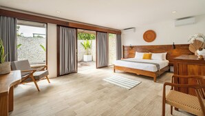 A modern bedroom with a wooden bed, a desk, and a chair. There is a large window with curtains and a view of greenery outside. - Villa Ivory 8Min Beach Pecatu byOrivista (Pecatu)