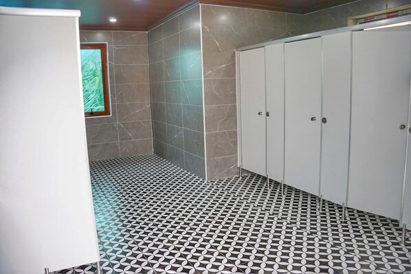 A bathroom with a patterned floor, a window with a view, and a set of lockers. - The Luna Tam Coc Hostel - Bar & Pool (Nam Hoa Lu)