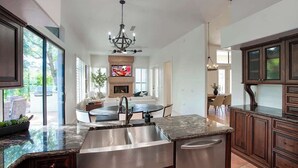 A spacious kitchen with a central island, stainless steel appliances, and dark wood cabinetry. - Princess Views-Pool & Spa-Walk to TPC Scottsdale (Scottsdale)