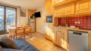 A modern kitchen with wooden cabinets, a built-in oven, and a dishwasher. - Cham Sud Iris361 Near Aiguille du Midi | Balcony Views, Chamonix, France (Chamonix)
