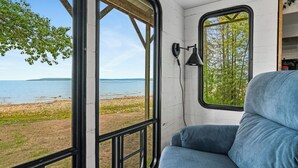 En husvagn med utsikt över en strand och en skog.