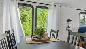 Ett matbord med en bordsduk, en vas med en växt och en ljusstake.