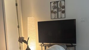 En moderne stue med en sofa, et fladskærms-tv og dekorative billeder på væggen.